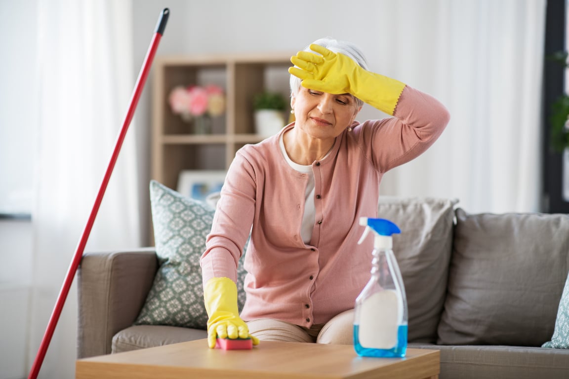 Tired Senior Woman Cleaning Table at Home